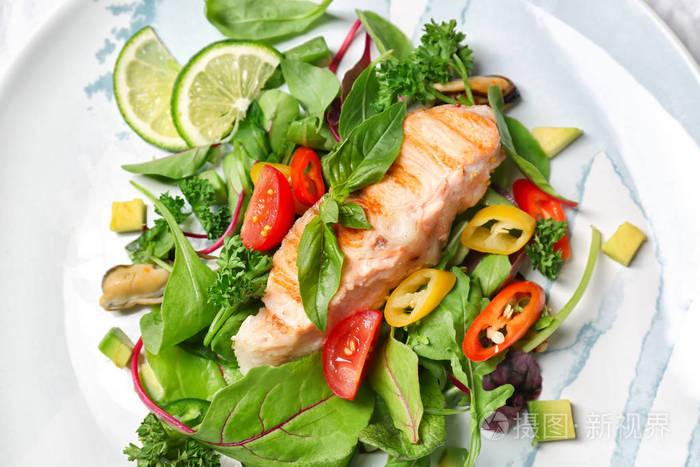 美味的鱼和新鲜的沙拉在盘子上特写