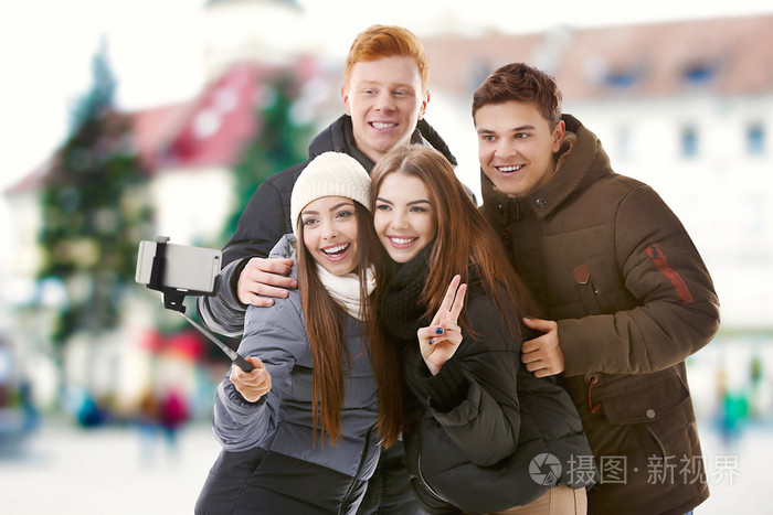 自拍在模糊城市街道背景下的年轻人群体