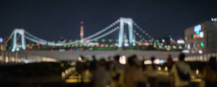 东京台场在东京彩虹桥的背景下行走在照明通路上的模糊图像