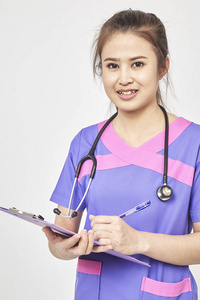 快乐亚裔年轻女性家庭医生用文件保存蓝色文件夹, 有友好的表达, 要看病人, 给一些建议, 孤立的灰色背景。医学概念