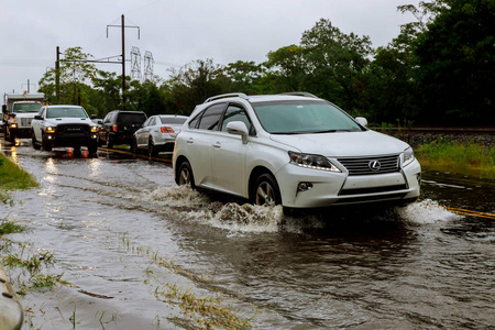 期间由于暴雨引发的洪水淹没的道路上行驶的汽车