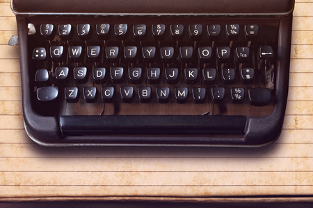在纸张背景上的老式打字机上的键盘