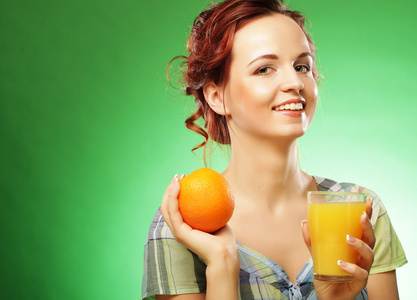 年轻快乐的女人喝橙汁