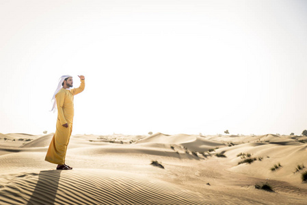 迪拜沙漠中的传统服饰的英俊阿拉伯男人