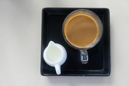 晨杯热咖啡与新鲜牛奶在黑盘子图片