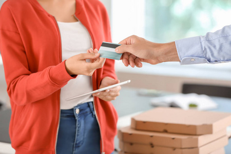 男子支付的比萨饼与信用卡在室内, 特写。食品配送服务