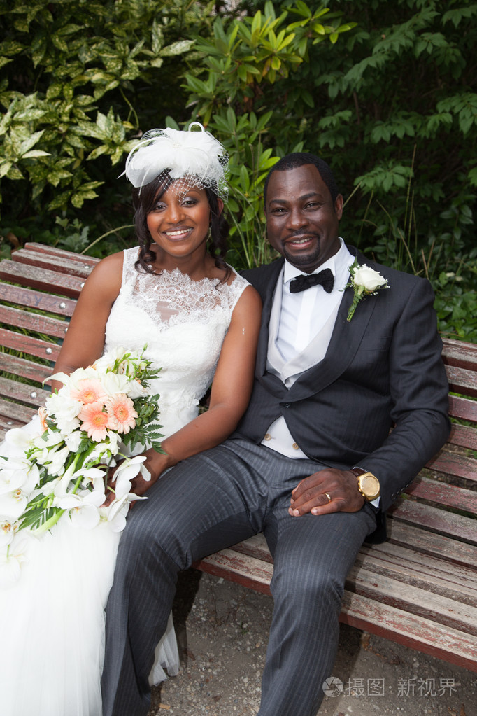 年轻的新结婚非洲裔美国夫妇在板凳上