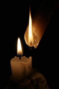 在黑暗中点燃蜡烛, 融化的蜡, 火焰的水滴。关门了圣诞节, 新年贺卡, 所有圣徒日, 所有圣夜, 教会, 宗教, 信仰, 祈祷