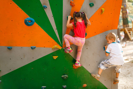 运动儿童攀登人造石在实际墙壁在健身房