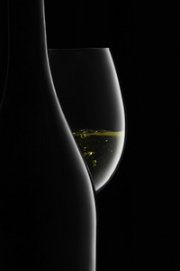 瓶子和杯子在一个黑色的白葡萄酒