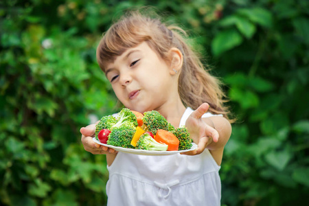 孩子吃蔬菜。夏天的照片。选择性焦点性质