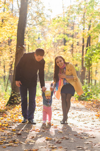 友好的家庭一起在秋天在公园散步