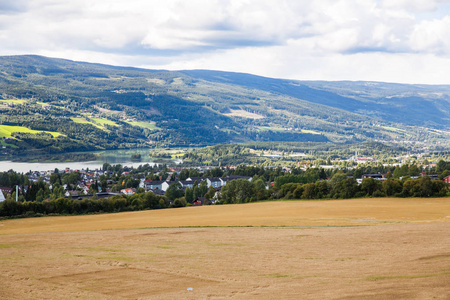 挪威利勒哈默尔镇的麦田河流和山脉景观