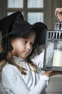 一个小女孩看着灯笼里的蜡烛的画像
