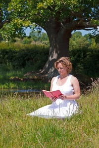 女人坐在草地上看书图片