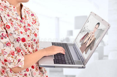 一个女人带着笔记本电脑在网上购物