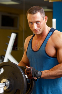 强壮的人正在准备他的健身训练机