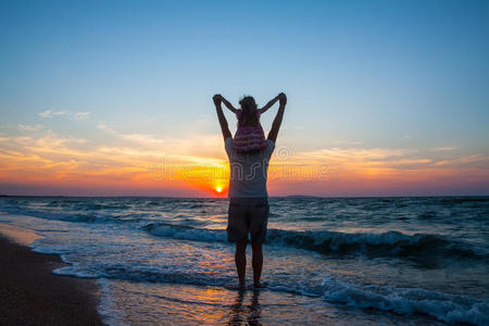 父亲夕阳夕阳下,父亲和小女儿在海滩上照片