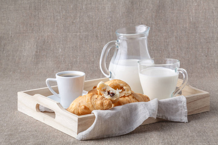 白色早餐托盘与牛奶在玻璃罐子, 牛角面包的侧面视图
