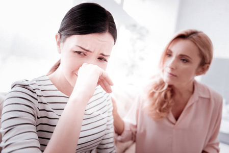 悲伤的女人在探望她经验丰富的精神分析师时哭泣