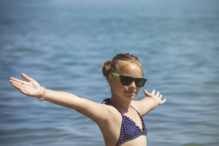 美丽的姑娘用举的手，微笑上海滩夏天度假的女人。自由旅行的概念