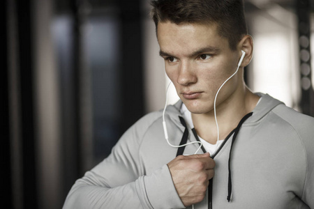 在健身房的耳机听音乐的年轻人图片