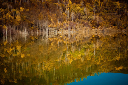 五颜六色的秋树倒影在湖中