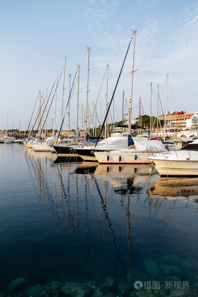 小船和船在码头在普拉,克罗地亚在日落时.桅杆,反映在海