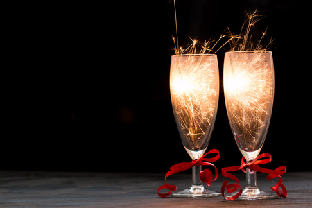 香槟和烟火在黑色背景上，快乐的圣诞节概念上的眼镜