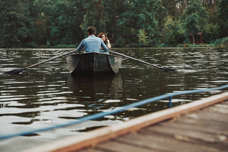 夫妇在船享受浪漫日期在湖在森林与树