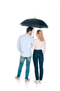 年轻夫妇抱着雨伞和微笑着彼此孤立的白色的后视图