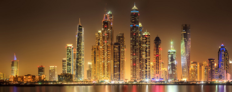 在日落，迪拜，阿拉伯联合酋长国的迪拜滨海湾与多云天空全景