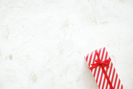 圣诞节和新年礼物包裹在喜庆五颜六色的红色和白色条纹图案纸。单一节日礼品盒白色 concreete 纹理表。关闭, 背景, 复制空