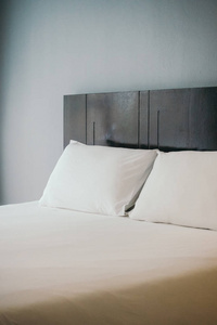 白色舒适枕头在床上装饰在旅馆床房间里