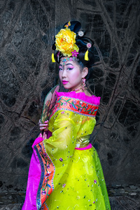 与中国传统服饰旗袍和控股中国扇子的亚洲女人。中国农历新年的概念
