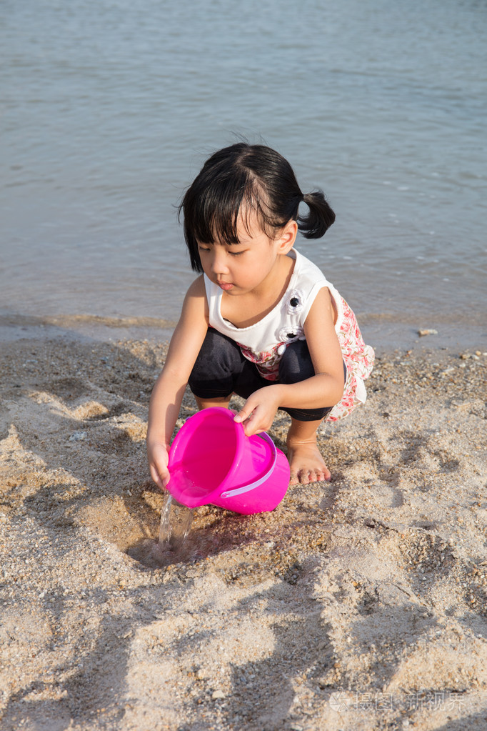 亚洲中国小女孩玩沙子在海滩