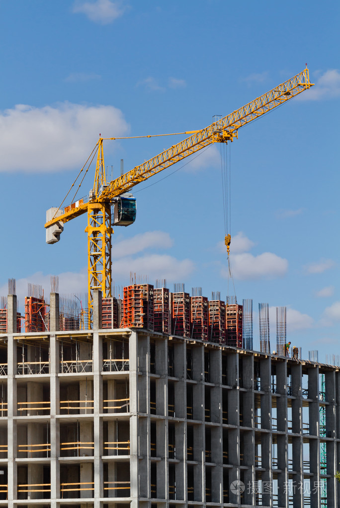 黄色建筑塔式起重机和在建房屋