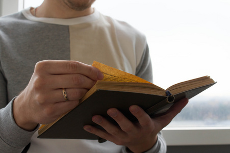 一个人读一本书,他手里拿着它照片