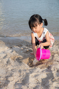 亚洲中国小女孩玩沙子在海滩