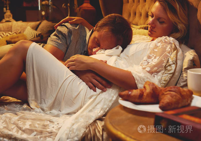 一对夫妇的年轻妻子和丈夫躺在床上的卧室在家里.