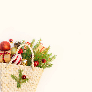 圣诞节或新年背景 篮子与彩色玻璃玩具和球, 冷杉树分支, 装饰品和礼物在白色背景
