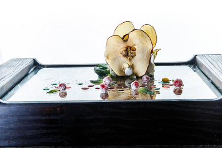 美味的软白色奶酪装饰干苹果和绿色沙拉在餐馆板反对白色背景