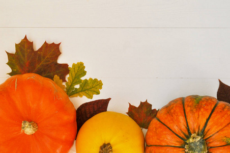黄色和橙色南瓜和秋天叶子在木质背景为收获秋天和感恩节主题