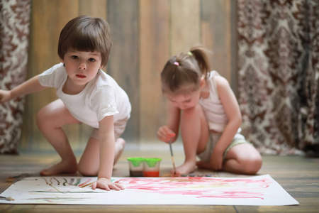 小孩子在一大张纸上画画。