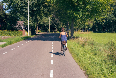 在农村公路上骑自行车的女人