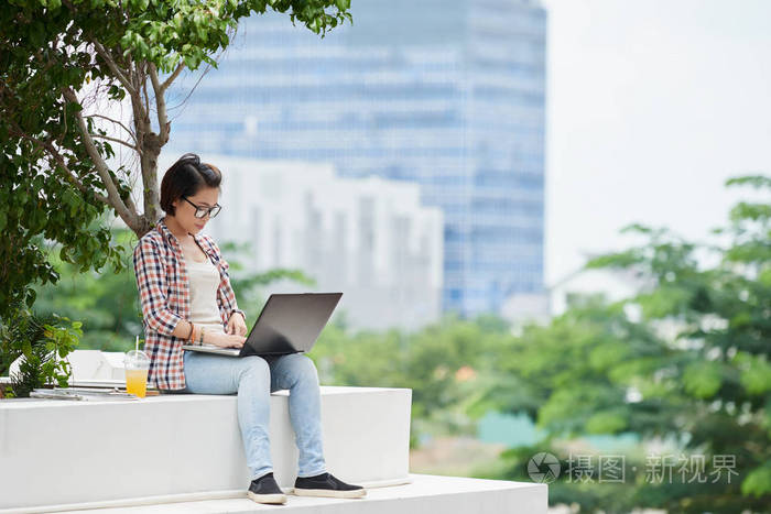 笔记本电脑享受户外工作的女人