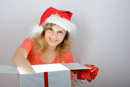 在圣诞老人的帽子打开一个盒子中的女孩