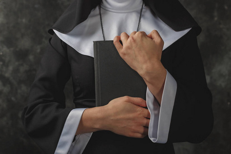 修女面纱特写手中按反对他胸部 bible.