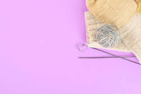 一种羊毛球, 针织针和针织袜子在彩色粉彩桌子上。针线 活
