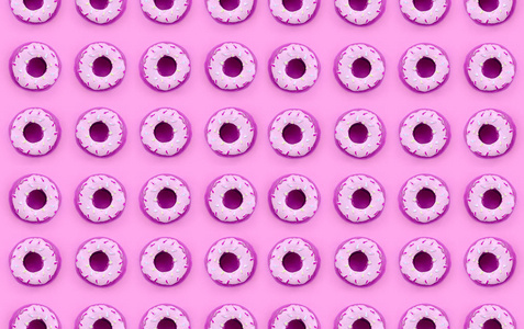 许多小的塑料甜甜圈位于柔和多彩的背景上。平躺最小模式。顶部视图